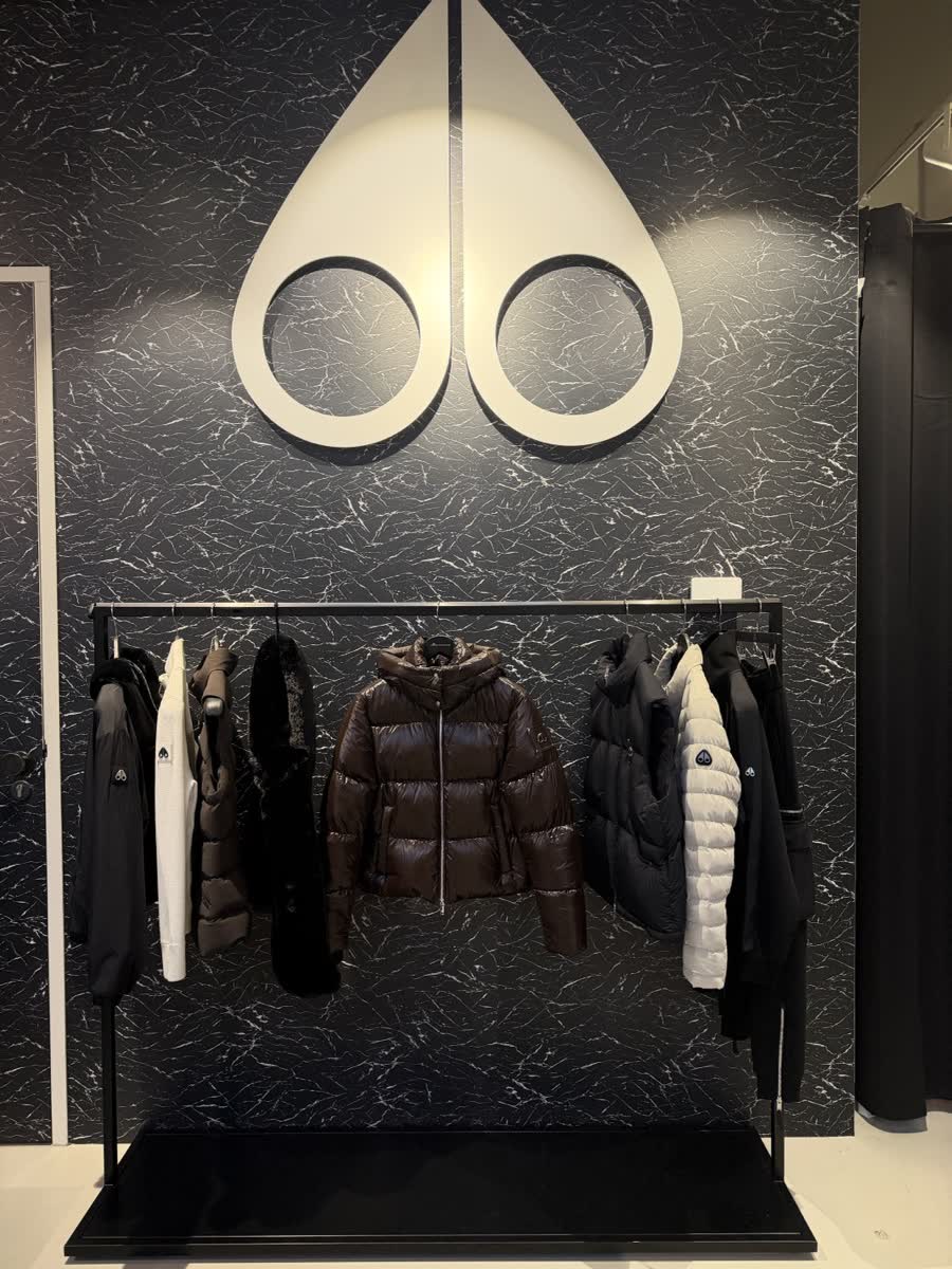 Moose Knuckles in-store display: the brand mark above a rack of outerwear