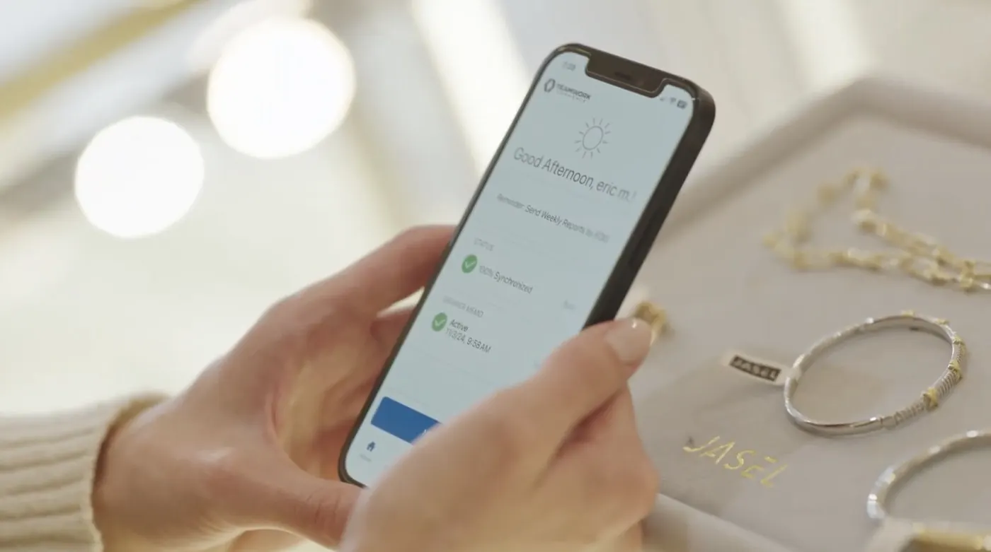 The Teamwork Commerce app on iPhone in a jewelry store, showing the associate home screen fully synchronized